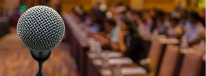 Microphone with rows of conference hall chairs in background