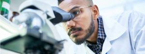 Lab scientist peering into microscope
